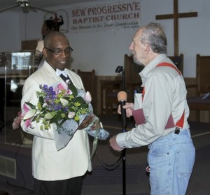 VFP President Jay Wenk presents flowers and a card to pastor Rev. Dr. G. Modele Clarke