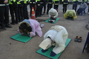 Activists surrounded by police as they make “100 Bows” in the early morning at the Jeju Island naval base entrance. Photo by ELLEN DAVIDSON