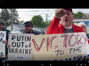 The man wearing the orange shirt and a baseball cap, shouting at Medea, is Kieran Knutson, from Minneapolis.