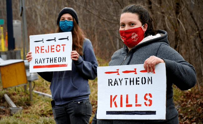 Girls with Signs that say Raytheon Kills