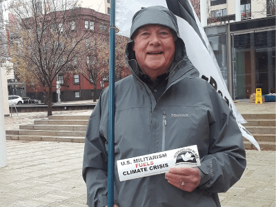 Image of CCMP member holding bumper sticker