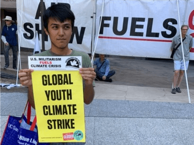 Image of teenager holding sign and bumper sticker