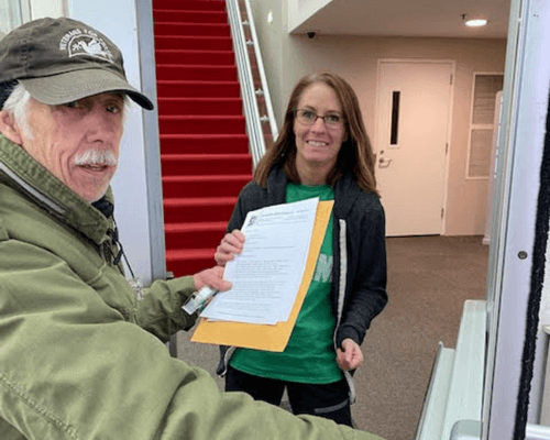 Image of member Barry R handing letter to Senator Klobuchar