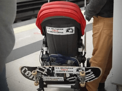Image of Bumper sticker on back of stroller and skateboard