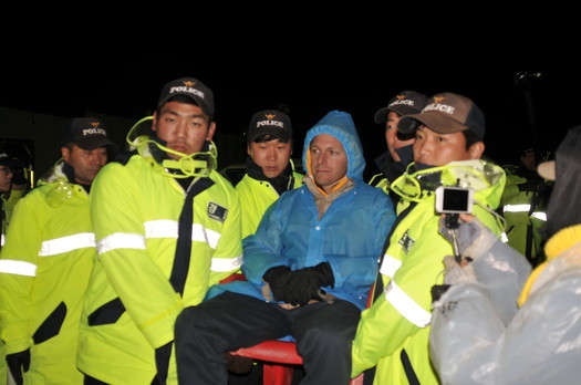 Iraq War veteran Mike Hanes is carried out of the base entrance by South Korean police. Photo by ELLEN DAVIDSON